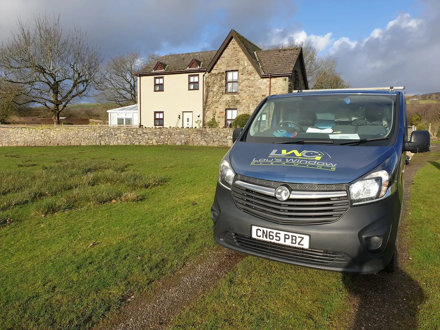 Lou's Window Cleaning Van parked in front of a house.